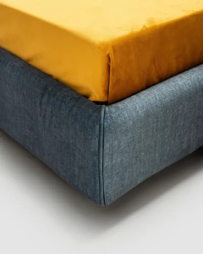 Detail of the corner of the SOREN bed's upholstered base