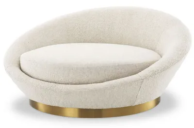 Fauteuil AURA, vue angulaire mettant en évidence la silhouette sculpturale et la base en laiton