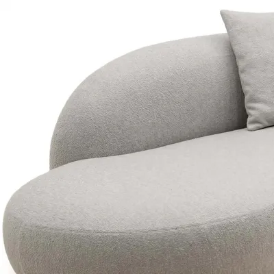Nahaufnahme der geschwungenen Rückenlehne und des Kissens des Ecksofas CALISTO