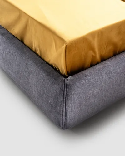 Detail of the corner of the VALEN bed's upholstered base