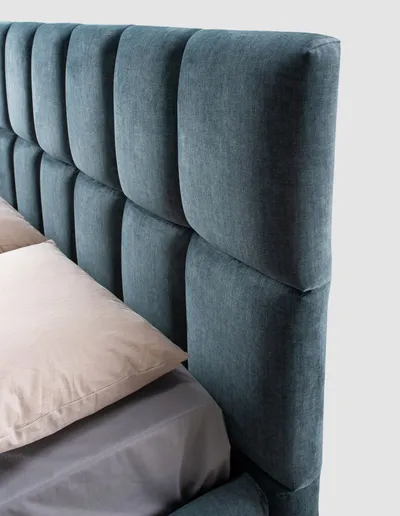 Detail of the padded headboard with square tufting of the NUVEN bed